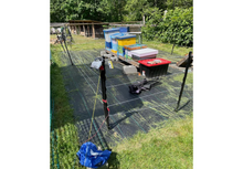 Load image into Gallery viewer, Base Camp Bear Sentry electric fence protecting apiary beehives in backyard
